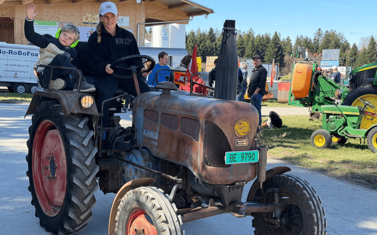 Frau mit Sohn auf einem Oldtimer-Traktor