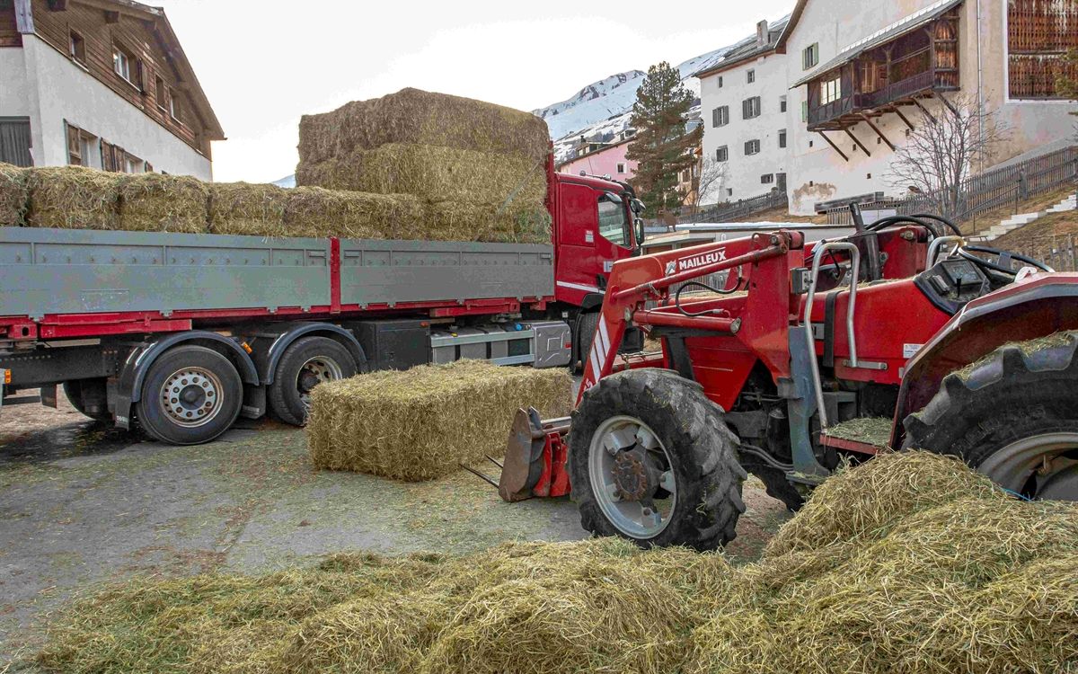 Umgefallene Heuballen, ein roter Frontlader im Vordergrund